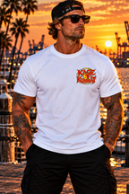 A man stands on a dock at sunset wearing a black T-shirt with a large 'Kage Kombat San Pedro' graphic on the left chest, with a tropical harbor and port cranes in the background.